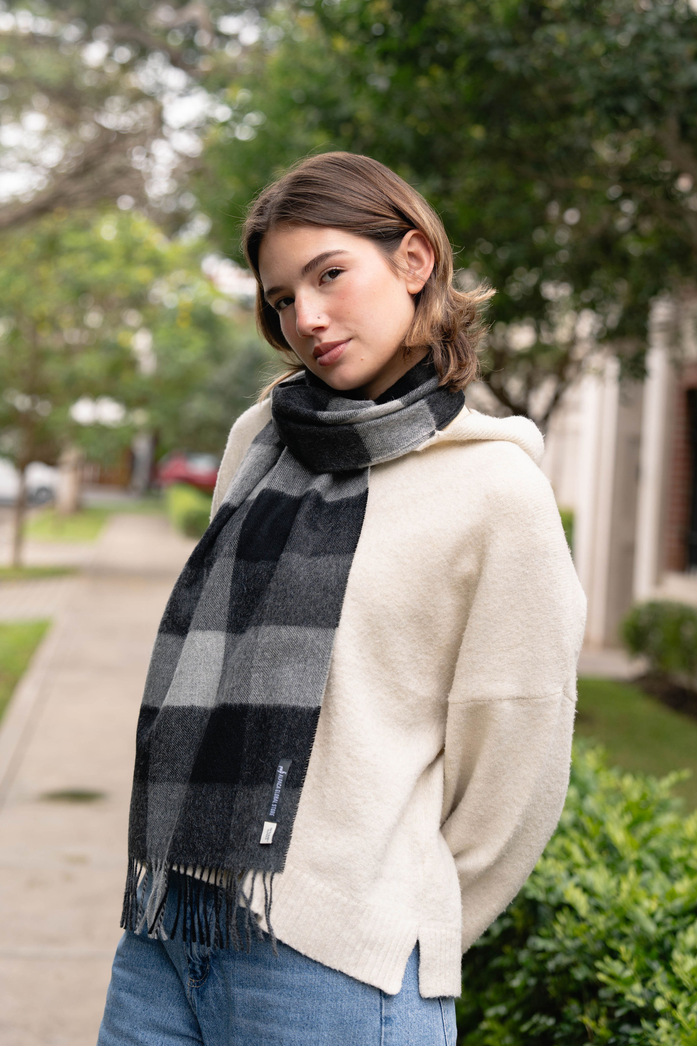 Bufanda de cuadros gris para mujer, hecha con lana de alpaca suave y cálida. Diseño elegante y moderno, ideal para los días fríos.