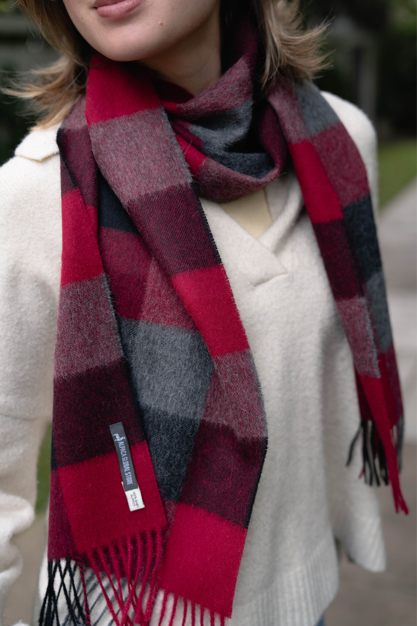 Stijlvolle rode geruite sjaal van alpaca voor dames. Zacht, warm en duurzaam – perfect accessoire voor koude winterdagen.
