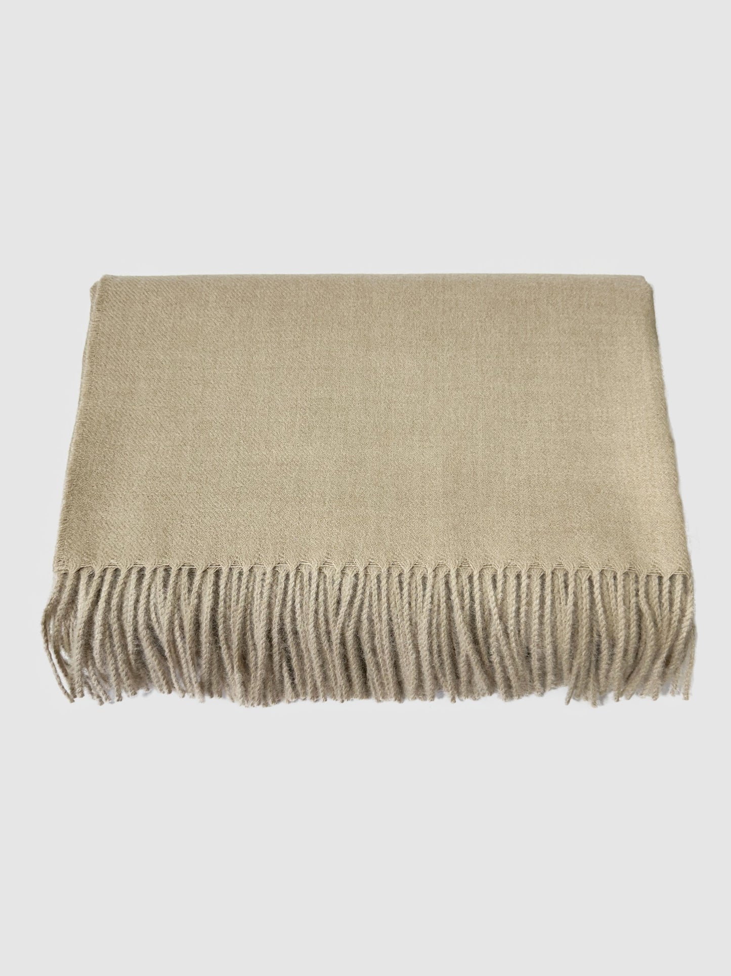 Solid beige baby alpaca blanket, hand-finished. Measures 180 cm in length by 130 cm in width.